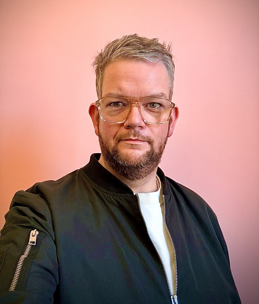 Tobi Neumann vor einer rosa Wand